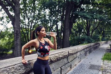 Latina Woman Drinks Water After a Workout