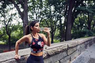 Latina Woman Drinks Water After a Workout