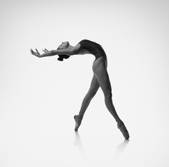 A ballerina makes a deflection backwards. Black and white photo.
