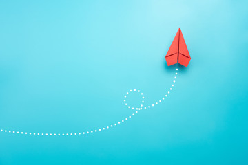 Red paper plane on blue background