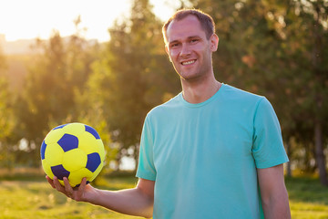 happy family playing football volleyball in summer park with a ball