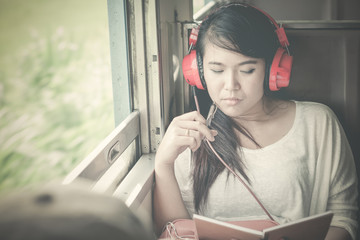 Asian woman listening to music and enjoy.