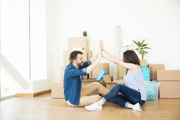 Delighted Couple Giving High-Five On Floor During Relocation