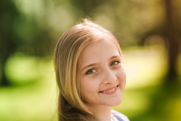 Naklejka premium Portrait of a beautiful young girl in the park