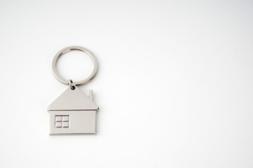 Key and keychain in the shape of a house isolated on white background.