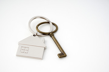 Key and keychain in the shape of a house isolated on white background.