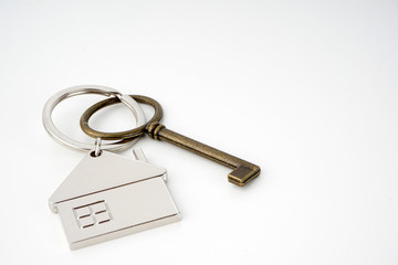 Key and keychain in the shape of a house isolated on white background.