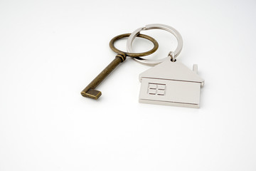 Key and keychain in the shape of a house isolated on white background.