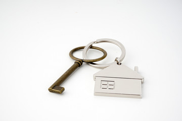 Key and keychain in the shape of a house isolated on white background.