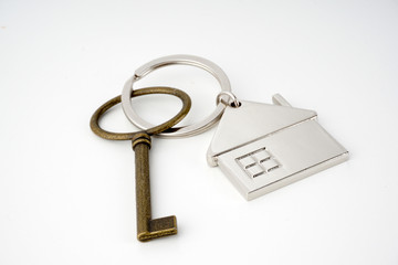 Key and keychain in the shape of a house isolated on white background.