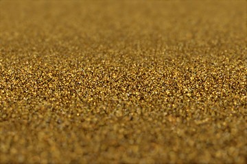 Abstract Glamour Background of Glitter Golden Particles. Award light background. Gold tint. Texture of Glitter Golden Particles. Abstract  background. 
