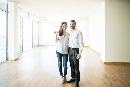 Smiling Man With Woman Holding Keys In New Apartment