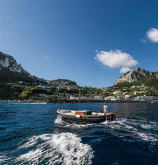 Fototapeta na wymiar CAPRI, CAMPANIA, ITALY - 22 AUGUST 2018: Iconic view od the island of Capri, from the sea, during a sunny day. 