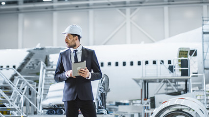 Businessman using Tablet in Aircraft Maintenance Terminal