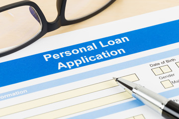 Personal loan application form with glasses, and pen