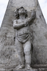 stone statue of a child on a pedestal