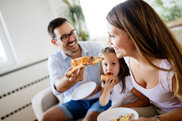 Happy family sharing pizza together at home