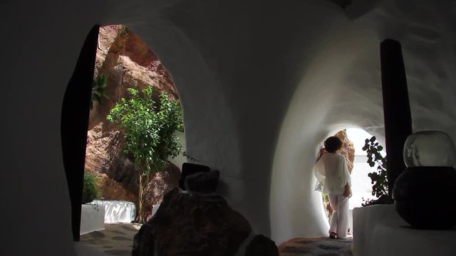 Woman leaning against a wall relaxes in Lagomar house museum in Lanzarote looking at the view