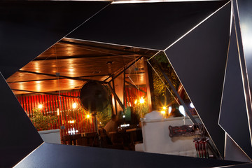 Closeup modern summer terrace of restaraunt, exterior. Futuristic, geometrical form. At night...
