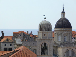 Fototapeta na wymiar View of Dubrovnik, historic Old Town with buildings and red roofs on the background of the sea, sky, nearby island, Croatia