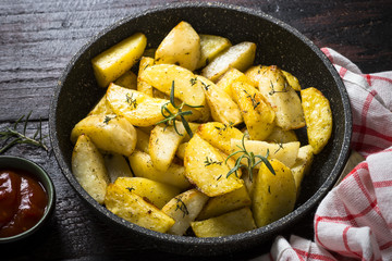 Baked potato with herbs in the pan.