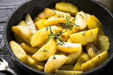 Baked potato with herbs in the pan.