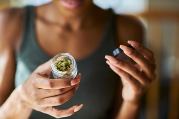 african american woman opening bottle of legal marijuana from dispensary close up - obrazy, fototapety, plakaty