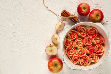 Аpple pie in the baking dish decorated with fresh sliced apples and cinnamon sticks. Vegetarian...