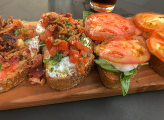 Bruschetta with delicious variety of toppings served on a board