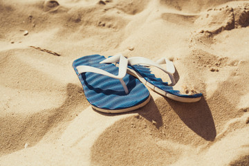 Fototapeta na wymiar Flip flops on the hot sand
