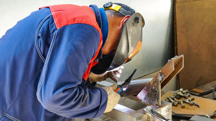 The professional welder works with argon-arc welding. Welds a pipe with a pipe DN50. Butt weld.