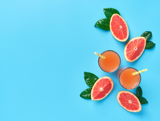 Two glass of  fresh grapefruit juice on a blue background.Top view