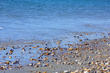 Blue sea washing on to a pebbly shore