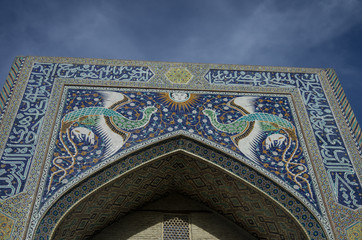 The facade of Nadir Divan-Beghi madrasah is decorated with multicolored majolica with a predominance of blue tones, Bukhara, Uzbekistan.