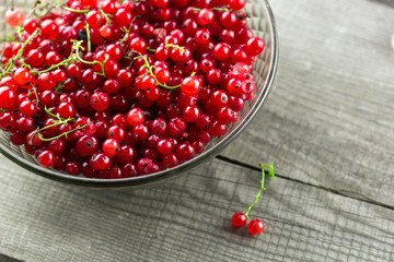 top view glass vintage bowl full of red ripe currant berries on a wooden table