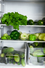 open fridge shelves and drawers full of green vegetables, raw food, veganism, healthy food, healthy lifestyle, food storage concept