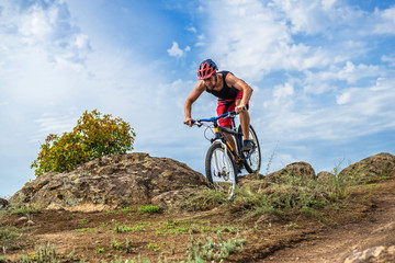 Fototapeta na wymiar Cyclist descending down the rock on a mountain bike, an active lifestyle.