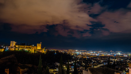 Night cityscape of Granada, Spain, with the Alhambra Palace in the background