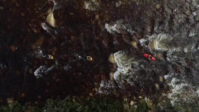 Aerial footage of white water kayaks paddling in the white water rapids on a freestone stream in the western cape of south africa during a winter storm.