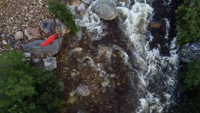 Aerial footage of white water kayaks paddling in the white water rapids on a freestone stream in the western cape of south africa during a winter storm.