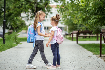 Fototapeta premium Two school friends met near the school. The concept of school, study, education, friendship, childhood