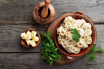 Russian pelmeni meat Dumplings with butter and greens.