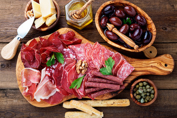 Antipasto platter cold meat with breadsticks, prosciutto, slices ham, beef jerky, salami and cheese...