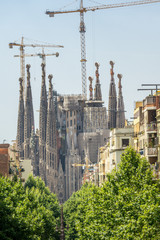 Barcelona, Spain  July, 2017: Cathedral of La Sagrada Familia from the Hospital of Sant Pau. It is designed by architect Antonio Gaudi and is being build since 1882.
