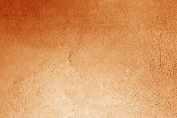 Grungy cement wall in orange color.