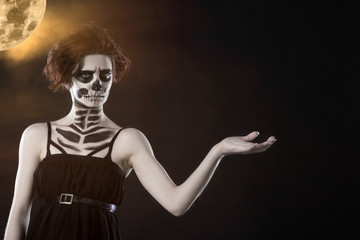 Fototapeta na wymiar Halloween. Portrait of young beautiful girl with make-up skeleton on her face