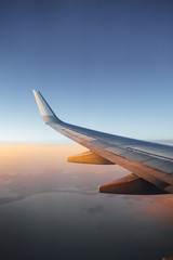 airplane wing against sunset sky background