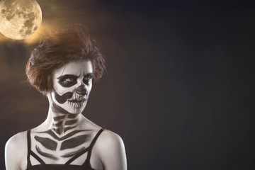 Halloween. Portrait of young beautiful girl with make-up skeleton on her face