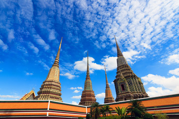 Fototapeta premium beautiful sky and cloud with Phra Maha Chedi Si Rajakarn is a stupa in Wat Pho, Bangkok. Ancient Stupas and pagoda in Wat Pho temple in Bangkok is among the best of Thailand's landmarks.