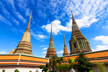 Fototapeta premium beautiful sky and cloud with Phra Maha Chedi Si Rajakarn is a stupa in Wat Pho, Bangkok. Ancient Stupas and pagoda in Wat Pho temple in Bangkok is among the best of Thailand's landmarks.